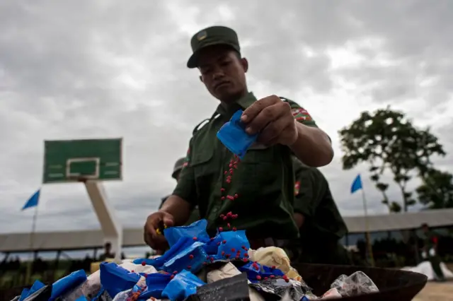 TOPSHOT-MYANMAR-THAILAND-UWSA-DRUG-CRIME
TOPSHOT - Members of UWSA (United Wa State Army) empties a packet of 'WY' also know as Ya Ba drug before they are set on fire during a drug burning ceremony to mark the UN's world anti-drugs day in Poung Par Khem, near the Thai and Myanmar border on June 26, 2017. The United Wa State Army, a 25,000-strong militia known as Asia's most heavily-armed drug dealers boast their own autonomous territories on the border with China and have close links with Beijing. (Photo by YE AUNG THU / AFP) (Photo by YE AUNG THU/AFP via Getty Images)