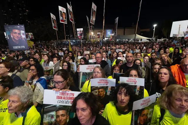 Протестная акция, люди держат портреты заложников.
