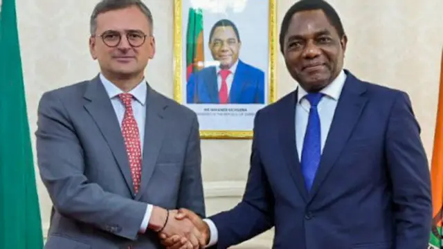 Le ministre ukrainien des Affaires étrangères Dmytro Kuleba (G) serre la main du président zambien Hakainde Hichilema