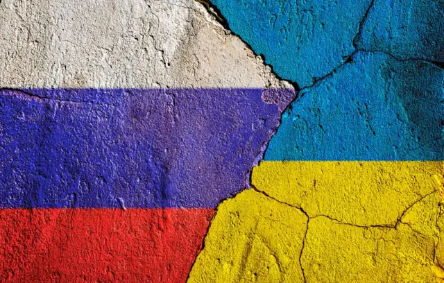 Banderas de Rusia y Ucrania pintadas en una pared resquebrajada