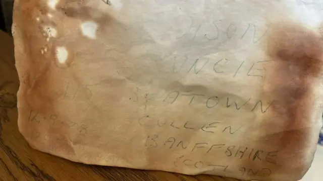 Una carta vieja y desteñida, con las palabras '78, Addison Runcie, Seatown, Cullen, Banffshire, Scotland' legibles.