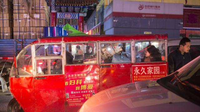 11月24日，北京通州，一位女士坐在一辆塞满行李的三轮车里。