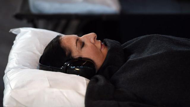 Marina Abramovic tumbada en una cama durante la presentación a la prensa de "Marina Abramovic: In Residence", en Sídney, el 23 de junio de 2015.