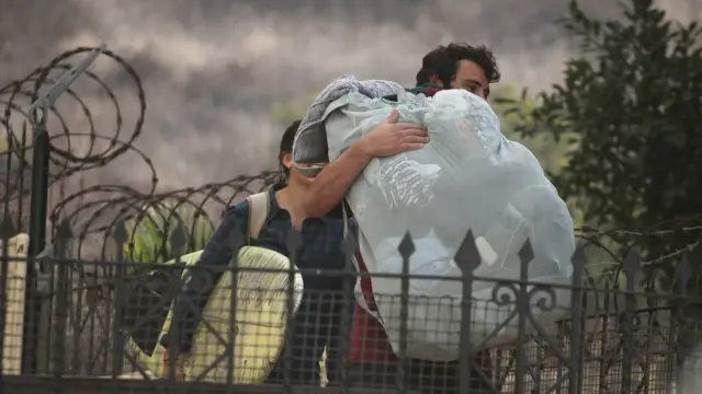 Una pareja abandona su hogar por la cercanía de un incendio en Ensenada, México