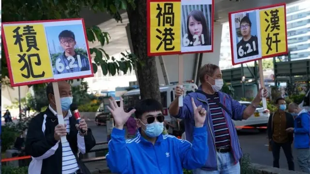 An activist shows the "Five demands, not one less!" gesture before the sentencing of pro-democracy activists Joshua Wong, Agnes Chow and Ivan Lam, at West Kowloon Magistrates" Courts in Hong Kong, China December 2, 2020.