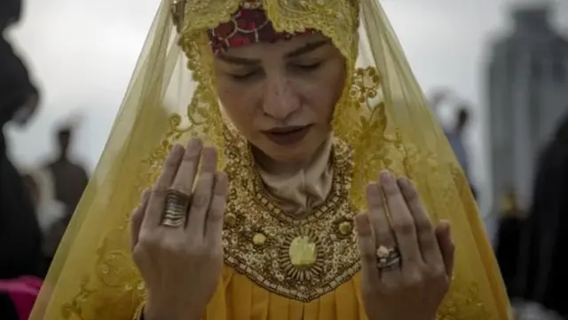 ਫਿਲਪੀਨਜ਼ ਦੇ ਇੱਕ ਜਨਤਕ ਪਾਰਕ ਵਿੱਚ ਇੱਕ ਔਰਤ ਈਦ ਦੀ ਦੁਆ ਮੰਗਦੀ ਹੋਈ