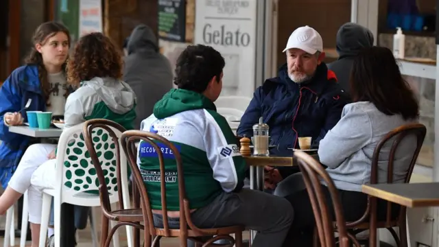 People sit at a beachside cafe in Bronte, Sydney on the first day of the city's reopening