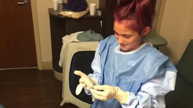 தாயின் பிரசவத்தில் உதவுவதற்கு முன்னர் மருத்துவ அங்கி அணிந்த சிறுமி