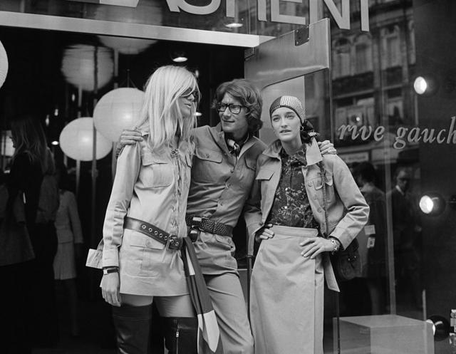 Yves Saint Laurent, estilista francês com duas modelos, Betty Catroux (à esquerda) e Loulou de la Falaise, do lado de fora de sua loja 'Rive Gauche' em 1969