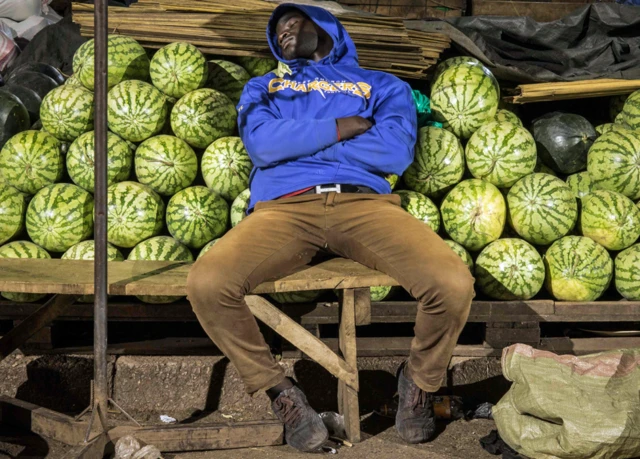 Un commerçant dort près de son étal de melons à Kampala, en Ouganda - mercredi 8 avril 2020