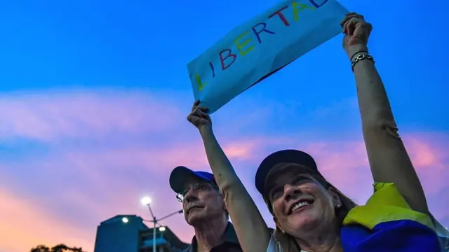 Manifestante con cartel en Venezuela.