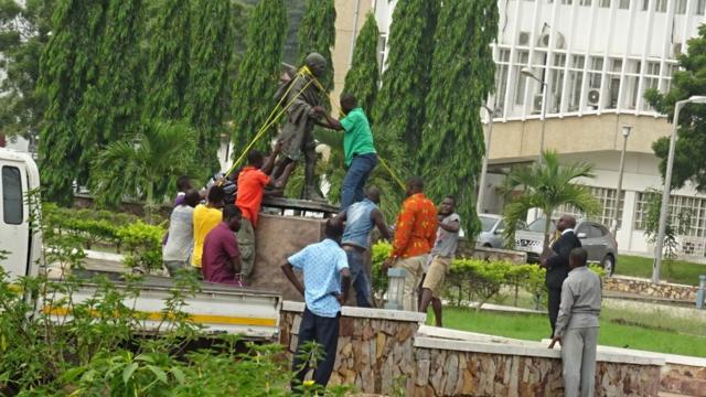 Люди демонтируют статую Махатме Ганди