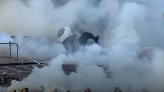 টিয়ারগ্যাসের ধোঁয়ার মধ্যে ক্যাম্পাস ছেড়ে যাচ্ছে কয়েকজন বিক্ষোভকারী