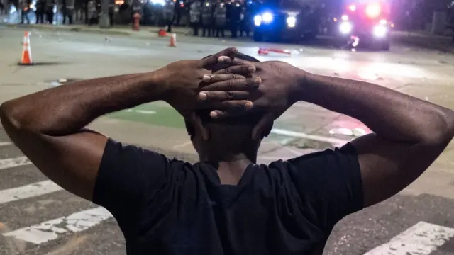 Black man under arrest with hands on head