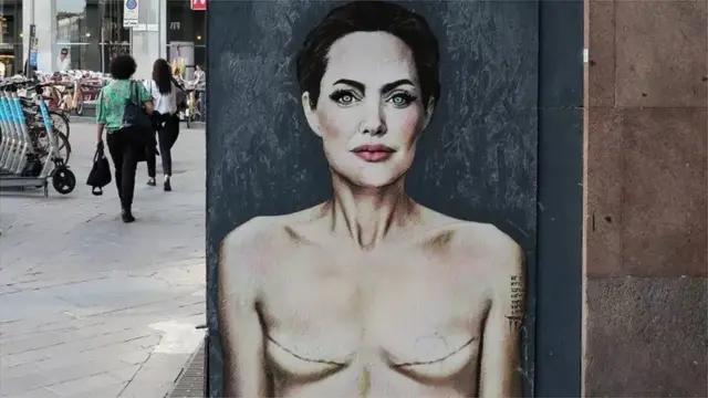"Aimez-vous", une peinture murale d'Alexsandro Palombo dans laquelle il dépeint Angelina Jolie montrant les signes d'une mastectomie lors de la Journée mondiale du cancer du sein. Piazza San Babila, Milan, mai 2023.