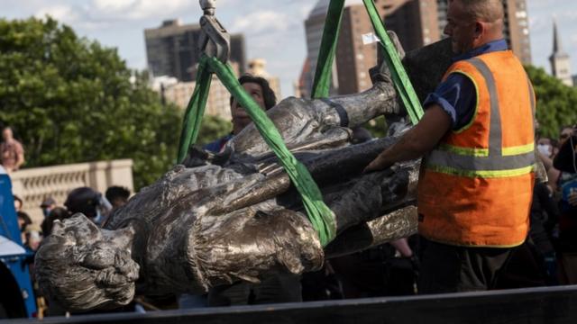 A statue of Christopher Columbus, which was toppled by protesters, is loaded onto a truck in St Paul, Minnesota