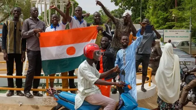 Des manifestants arborent le drapeau du Niger lors d'un rassemblement à Niamey, au Niger, le 3 août 2023.