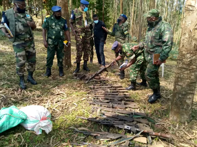 Bamwe mu bagize itsinda rya EJVM bagenzura imbunda zafatanywe aba barwanyi