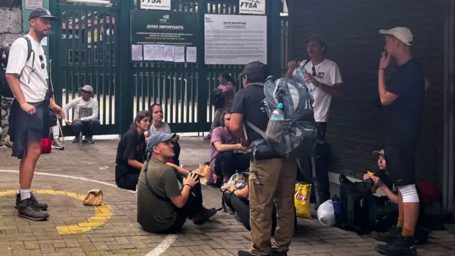 Tourists wait outside the Machu Picchu train station after the railway service was suspended due to damages allegedly caused by protesters in Machu Picchu, Peru, on January 21, 2023.