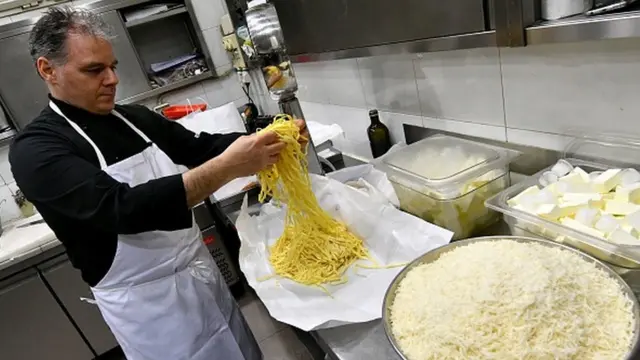 Un chef prepara la pasta con salsa Alfredo