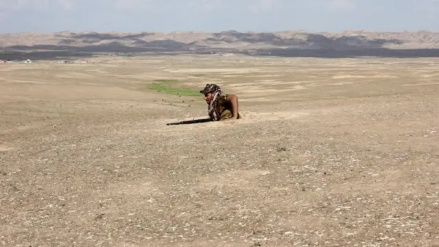 شخص مسلح يخرج من حفرة