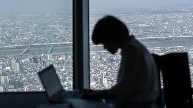 Travailleur japonais avec Tokyo à l'horizon.