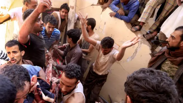 يمنيون ينتشلون جثة من تحت أنقاض في صنعاء إثر غارة شنتها قوات التحالف بقيادة السعودية (صورة أرشيفية)