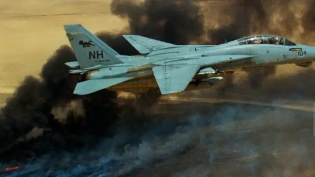 Un avion Tomcat survole les incendies de puits de pétrole