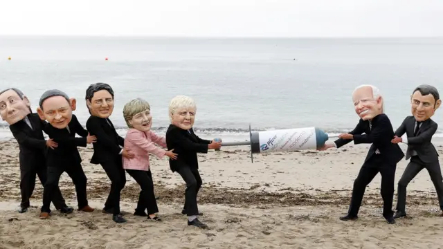 Des manifestants au G7 se déguisent en dirigeants mondiaux pour protester contre le nationalisme vaccinal