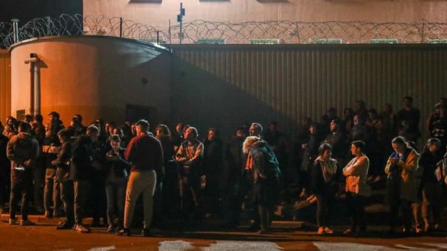 People wait for detained protesters to leave a temporary detention facility