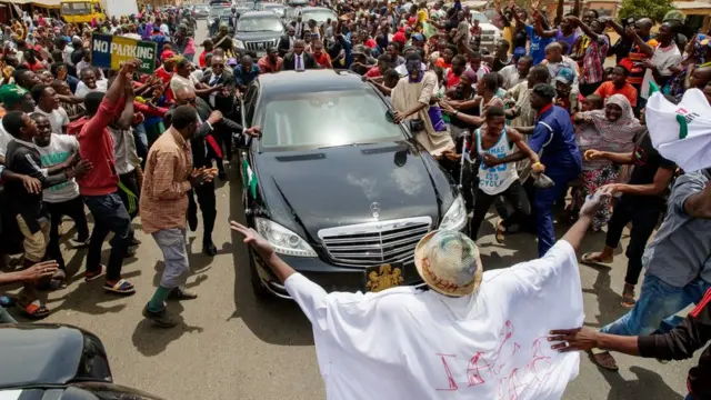 Ọdọmọkunrin kan duro si oju ọna niwaju ọkọ ayọkẹlẹ Aarẹ Buhari