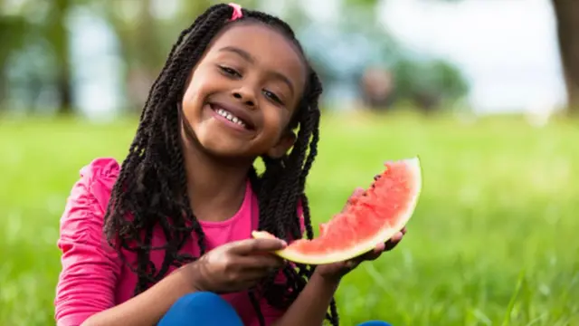 Enfant avec une pasthèque.