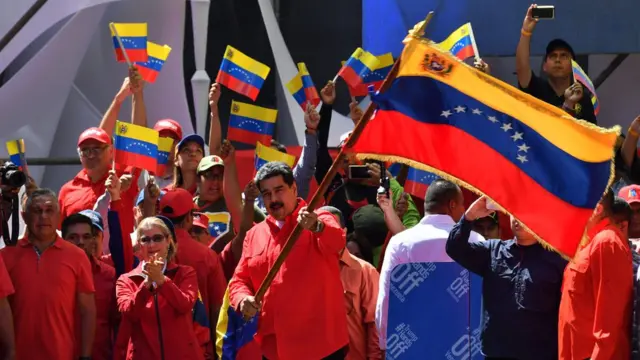 Venezuelan President Nicolas Maduro (C) waves the national flag during a pro-government march in Caracas, on February 23, 2019