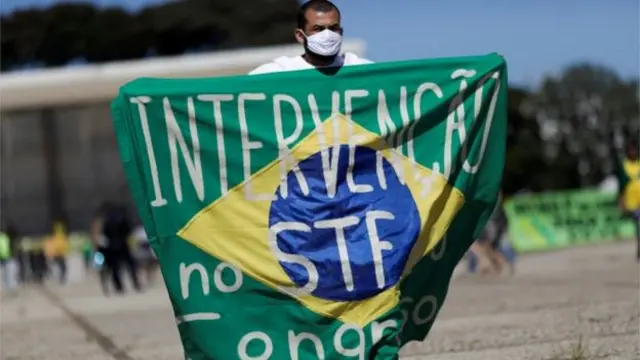 Homem segura faixa pedindo intervenção no STF