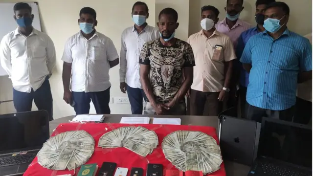 கைது செய்யப்பட்ட சந்தேக நபருடன் போலீஸ் அதிகாரிகள். கைப்பற்றப்பட்ட பணம், பொருள்கள்.