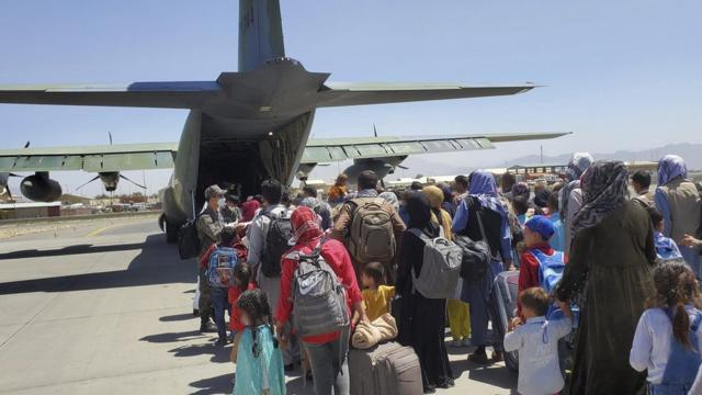 Afghans who have worked for South Koreans in their war-ravaged nation and their family members boarding a South Korea military plane at an airport in Kabul, Afghanistan, 25 August 2021,