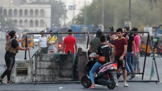 Iraqi demonstrators set up a barrier during a protest over poor public services in Baghdad