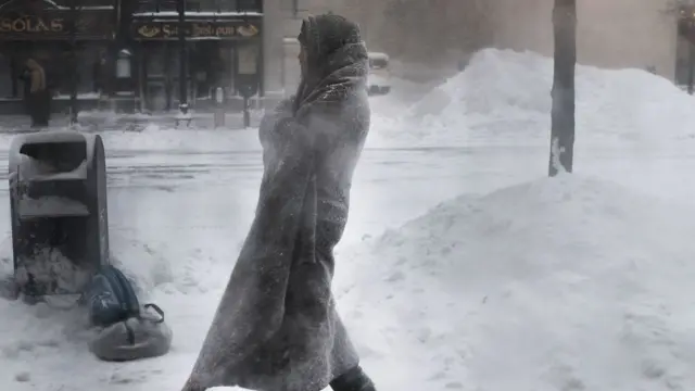 seorang pria melawan dingin dengan menggunakan selimut