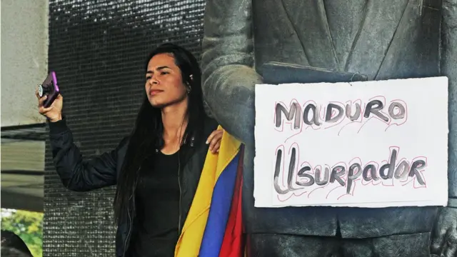 Mulher segura cartaz que diz: 'Maduro usurpador'