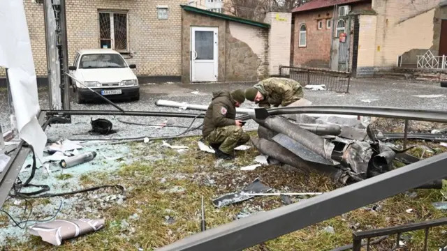 கீஃப்-ல் ஒரு தெருவில் உள்ள ஷெல் எச்சங்களை காவல்துறை மற்றும் பாதுகாப்பு அதிகாரிகள் ஆய்வு செய்கின்றனர்