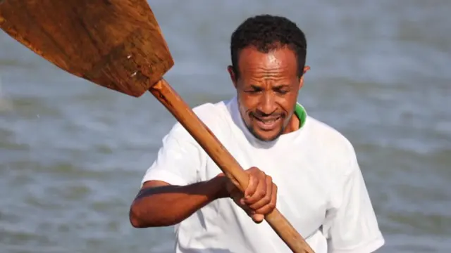 ተወዳዳሪዎች ነጭ ማሊያ ለብሰው በእንጨት ማንኪያቸው ውሃውን ሲጨልፉ ተስተውለዋል