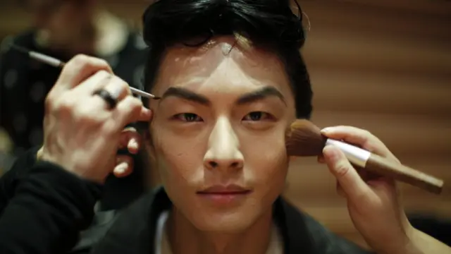 Un hombre es maquillado.