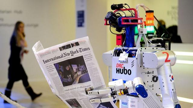 Робот держит газету во время показа на Всемирном экономическом форуме в Давосе, 22 января 2016 года