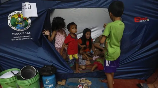 Family inside of a government tent