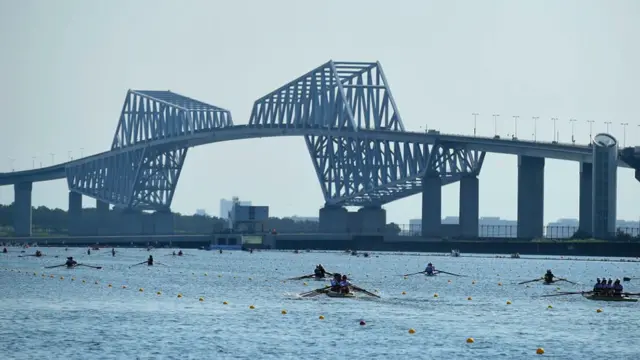 Competitors warm up prior to the start of the World Rowing Junior Championships, Tokyo 2020 Olympic Games test event, at Sea Forest Waterway with the Tokyo Gate Bridge in the background