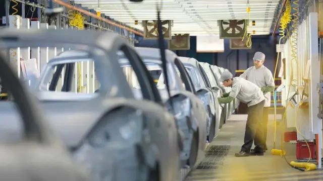 자동차 제조 공장에서 직원들이 일하는 모습