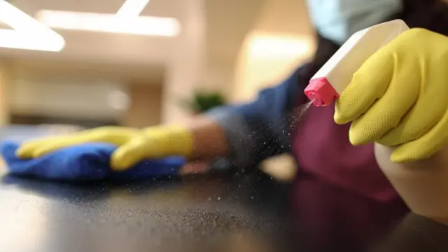 Manos con guantes de limpieza