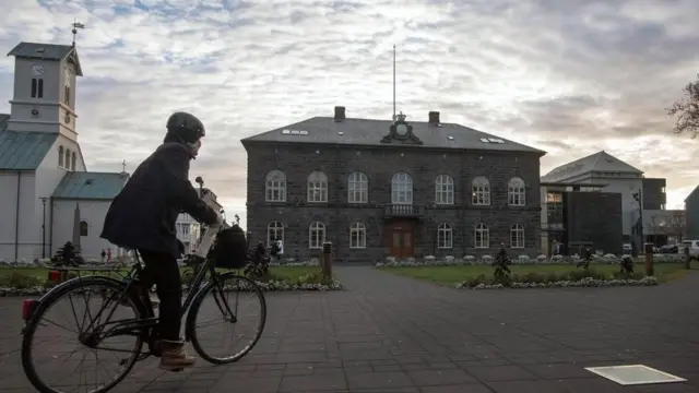 رجل يسير بدراجته في الشارع في أيسلندا