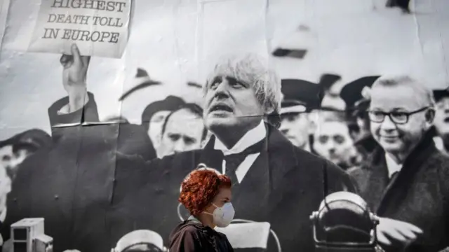 Прохожий на фоне плаката с изображением Бориса Джонсона