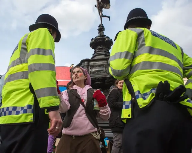 Policías frente a una manifestante en Trafalgar Square, Londres.